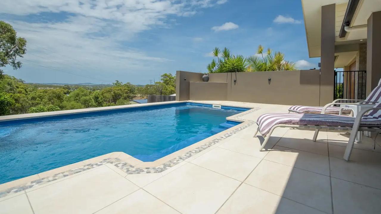 The home boasts an in-ground swimming pool and overlooks the city with water and mountain views. Picture: Contributed