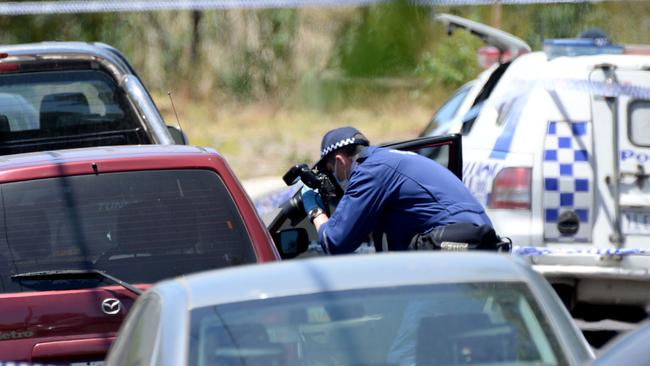 Forensic investigators can be seen taking pictures and samples from the scene. Picture: Andrew Henshaw