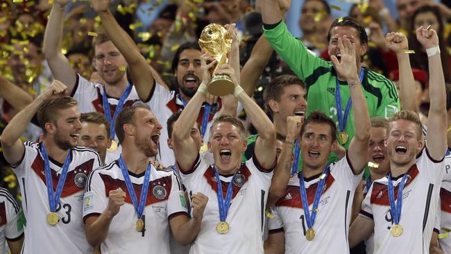 Germany's Bastian Schweinsteiger holds up the World Cup trophy as the team celebrates.