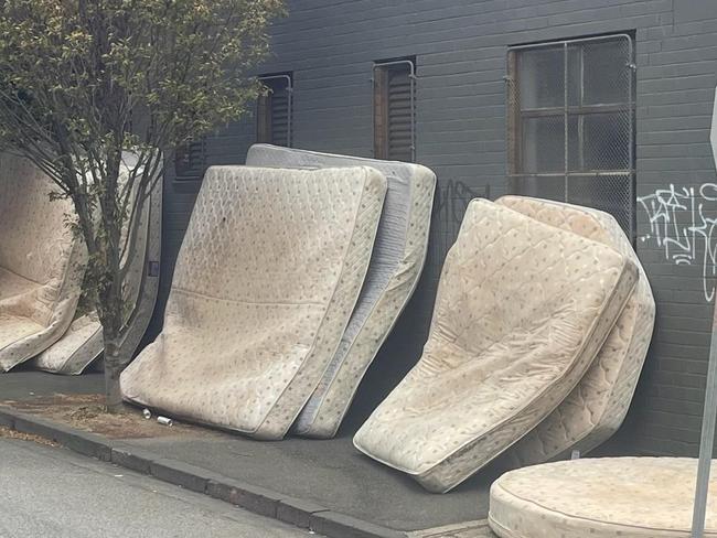 Used mattresses stacked up outside Gotham City.