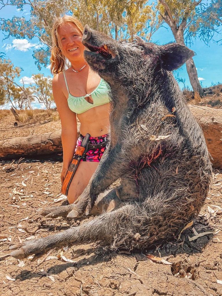 Paige poses with a dead feral pig.