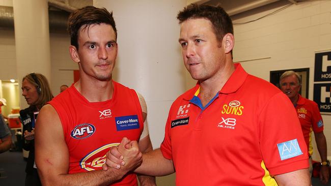 Stuart Dew and Jarryd Lyons embrace after a Gold Coast win last year. Picture: Getty Images 