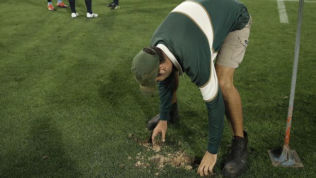 Ground staff replace the divots during the clash between the Reds and Waratahs. Picture: Ryan Pierse/Getty Images