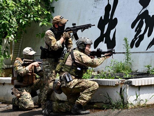 This photo taken on June 18, 2022 shows Taiwanese civilians in tactical gear and replica weapons taking part in an urban warfare workshop in Linko district, New Taipei City.