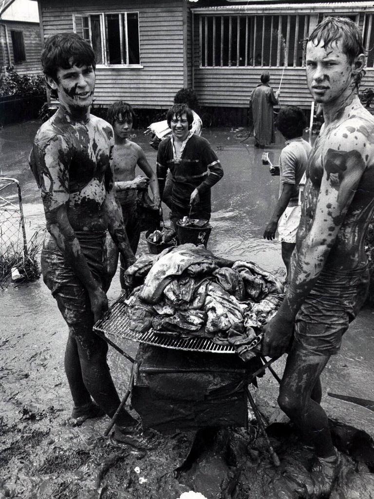 Residents and youngsters attempt to clean up and rescue what they can from the mud.