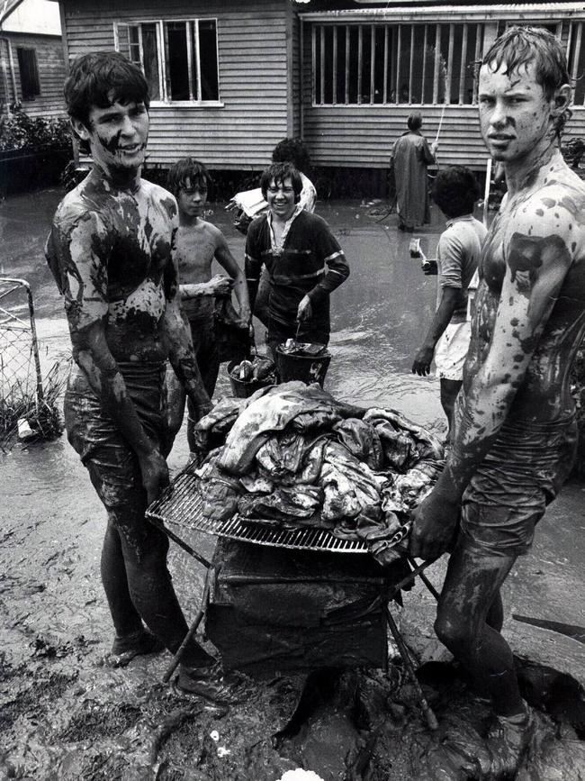 Residents and youngsters attempt to clean up and rescue what they can from the mud.