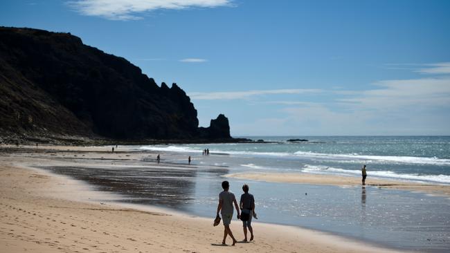 A couple walks on the beach in Praia da Luz in Algarve, southern Portugal.