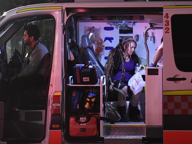 Sharon Hackers sits in an ambulance outside Enmore 7-Eleven after being axed in the head by Amati. Picture: Gordon McComiskie 