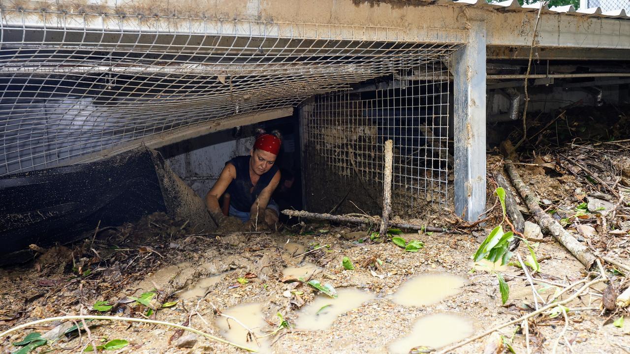 Ellis Beach Bar and Grill manager Cecilia Marland digs mud out of the popular seaside eatery with her bare hands. Picture: Brendan Radke