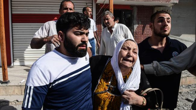 People escort a woman out from her home after a mortar fired from Syria struck her house in Akcakale, Turkey. Picture: Getty Images