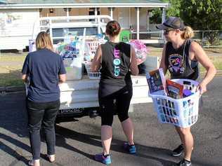 CHRISTMAS SPIRIT: Irene Tanks, Hamey Hayllor and Cass Schultz unloading the hampers put together by Physical Fix members. Picture: Shannon Hardy