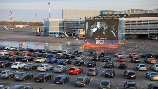 People sit in their cars to watch a movie at the Autokino drive-in cinema at a Lithuanian airport where the Vilnius International Film Festival was presented during the coronavirus crisis last month. Picture: AFP