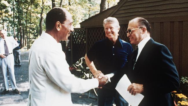 This file photo shows former Egyptian President Anwar al-Sadat (L) as he shakes hands with former Israeli Premier Menachem Begin, as former US President Jimmy Carter looks on, 06 September 1978 at Camp David, the US presidential retreat in Maryland. Egypt began peace initiatives with Israel in late 1977, when Sadat visited Jerusalem. A year later, with the help of Carter, terms of peace between Egypt and Israel were negotiated at Camp David. A formal treaty, signed 26 March 1979 in Washington, DC, granted full recognition of Israel by Egypt, opened trade relations between the two countries, and limited Egyptian military buildup in the Sinai. Israel agreed to return a final portion of occupied Sinai to Egypt.