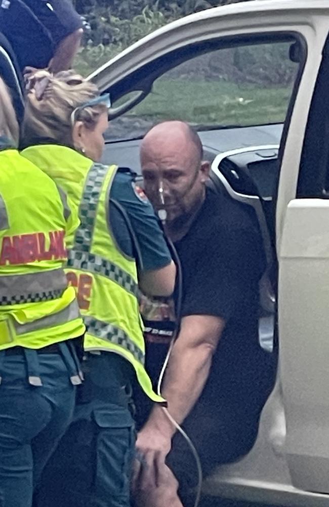 A man is treated at the scene for shock and smoke inhalation after he reportedly pulled a woman from one of the vehicles before it exploded. Picture: Sam Stolz