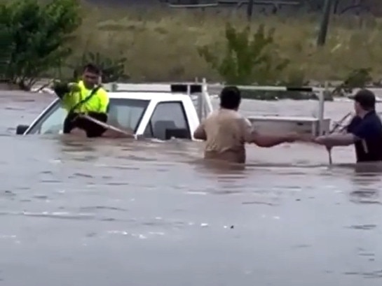 The moment a man is rescued from his ute in floodwaters at Westbrook Creek, near Toowoomba. Picture: Brian Sampson