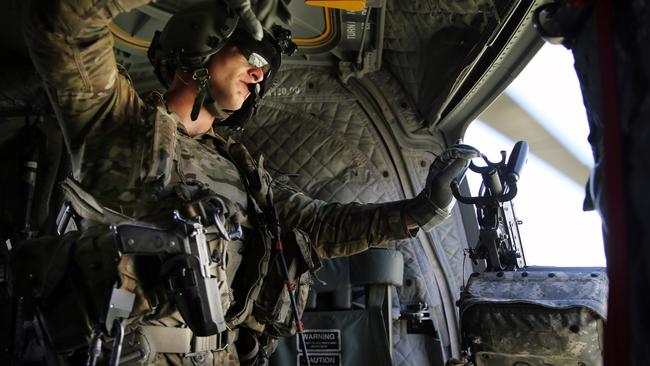 A loadmaster on board a US Chinook helicopter during a flight over Kabul. Picture: Gary Ramage