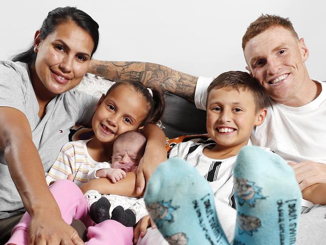 Emma MacNeill and Mitch Robinson from the Brisbane Lions with Charli Robinson, 6, Chance Robinson, 8, and Maali Robinson, 2weeks with their trackpants for Tracky Dack Day, Brisbane 27th of May 2022.  (Image/Josh Woning)