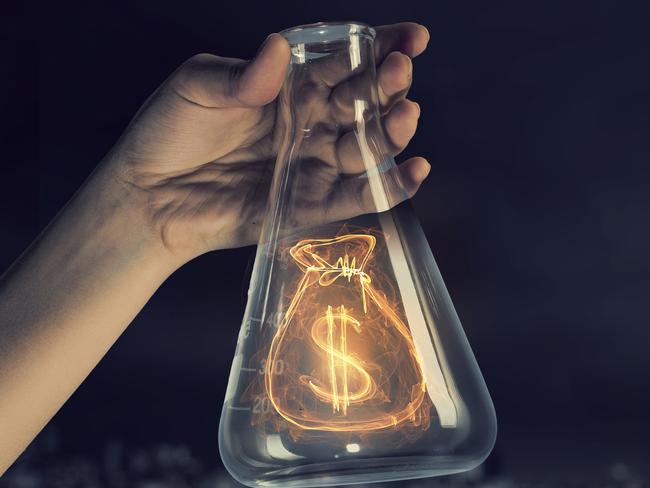 Close up image of human hand holding test tube with money symbol