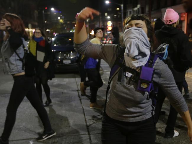 An anti-Trump protester rallies in Seattle's Capitol Hill neighbourhood. Picture: AP Photo/Ted S. Warren