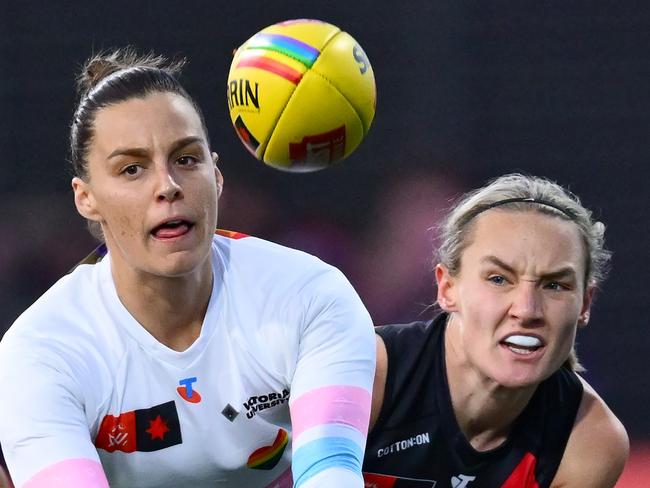 MELBOURNE, AUSTRALIA - OCTOBER 11: Deanna Berry of the Bulldogs handballs whilst being tackled during the round seven AFLW match between Western Bulldogs and Essendon Bombers at Mission Whitten Oval, on October 11, 2024, in Melbourne, Australia. (Photo by Quinn Rooney/Getty Images)