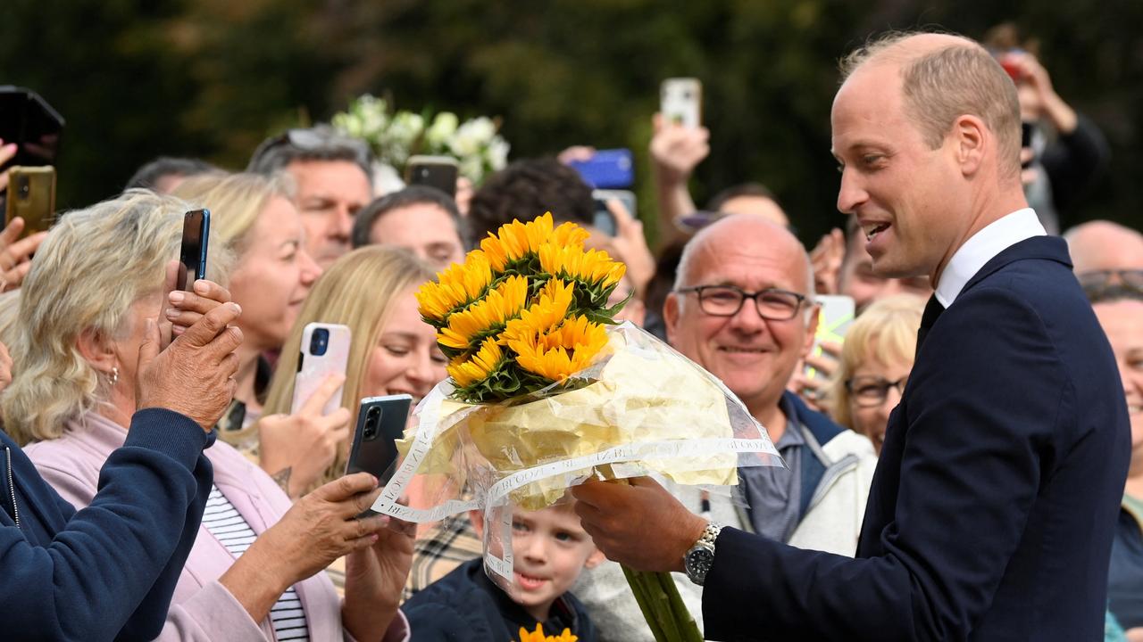 William is given a bunch of sunflowers by a member of the public. Picture: Toby Melville – WPA Pool/Getty Images