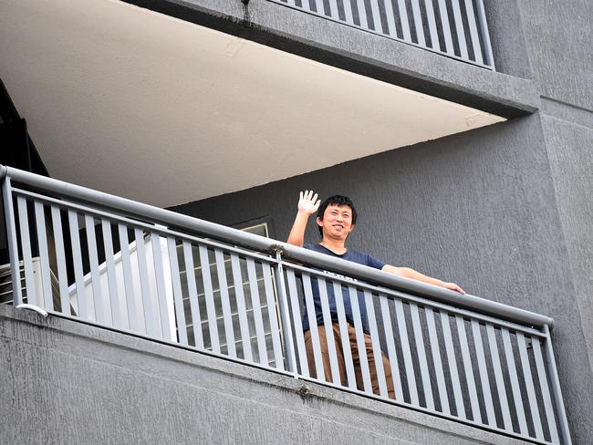 A quarantined guest waves from his balcony at the Hotel Grand Chancellor in Spring Hill, Brisbane. Picture: NCA NewsWire / Dan Peled