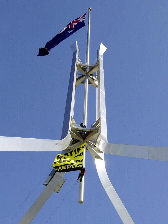 Greenpeace activists Catherine Fitzpatrick and Peter Morris climb Parliament House in Canberra on August 20, 2002 to display a banner demanding the federal government ratify the Kyoto protocol to reduce greenhouse gas emissions. Picture: Michael Jones