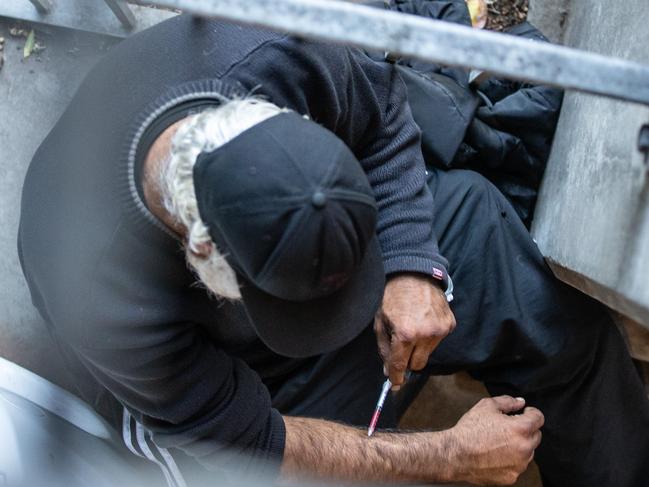 A man is seen injecting in a carpark next to North Richmond Community Health, which houses the medically supervised injecting room. Picture: Sarah Matray