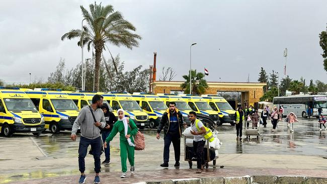 Passengers fleeing the war-torn Gaza Strip arrive to the Egyptian side of the Rafah border crossing this week. Picture: AFP