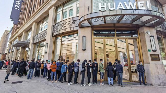 Customers wait in front of a Huawei store ahead of sales of the newly launched Huawei Mate40 mobile phone series in Shanghai. Picture: AFP