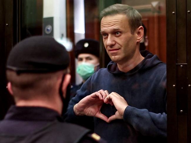 (FILES) In this file photo taken on February 02, 2021 This screen grab from a handout footage provided by the Moscow City Court press service shows Russian opposition leader Alexei Navalny, charged with violating the terms of a 2014 suspended sentence for embezzlement, gesturing a heart shape from inside a glass cell during a court hearing in Moscow. - Jailed Kremlin critic Alexei Navalny is in great pain, his lawyer said on March 25, 2021 after visiting him in prison, adding that allies were afraid "for his life." (Photo by Handout / Moscow City Court press service / AFP) / RESTRICTED TO EDITORIAL USE - MANDATORY CREDIT "AFP PHOTO / Moscow City Court press service / handout" - NO MARKETING - NO ADVERTISING CAMPAIGNS - DISTRIBUTED AS A SERVICE TO CLIENTS