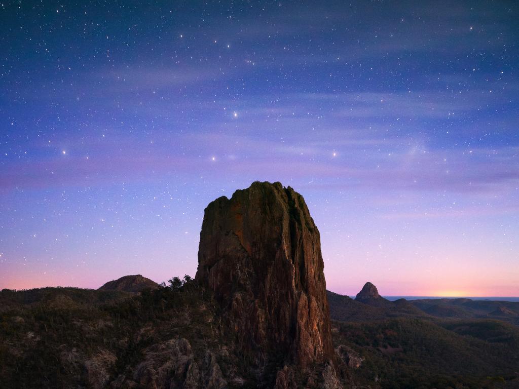 Stars lighting up the night sky over the Breadknife rock formation in Warrumbungle National Park.