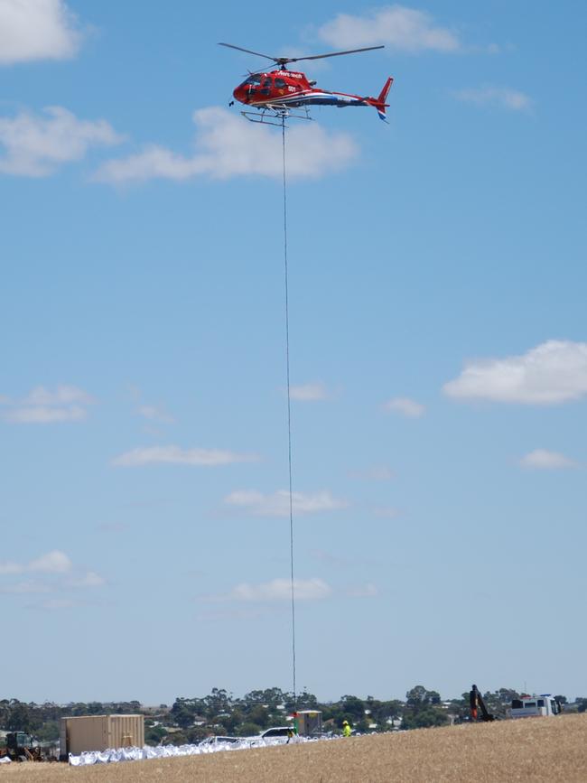 A helicopter collects one of the massive 'Bulka Bags' for Cowirra. Picture: Dylan Hogarth