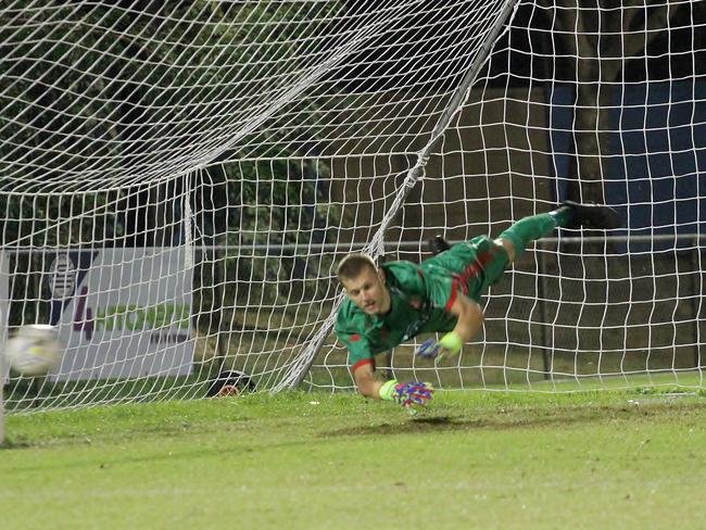 Darwin Olympic goalkeeper Kane McAdam dives to his right to make a spectacular penalty save in a FFA Cup classic in late June. Picture: Lou Reeve