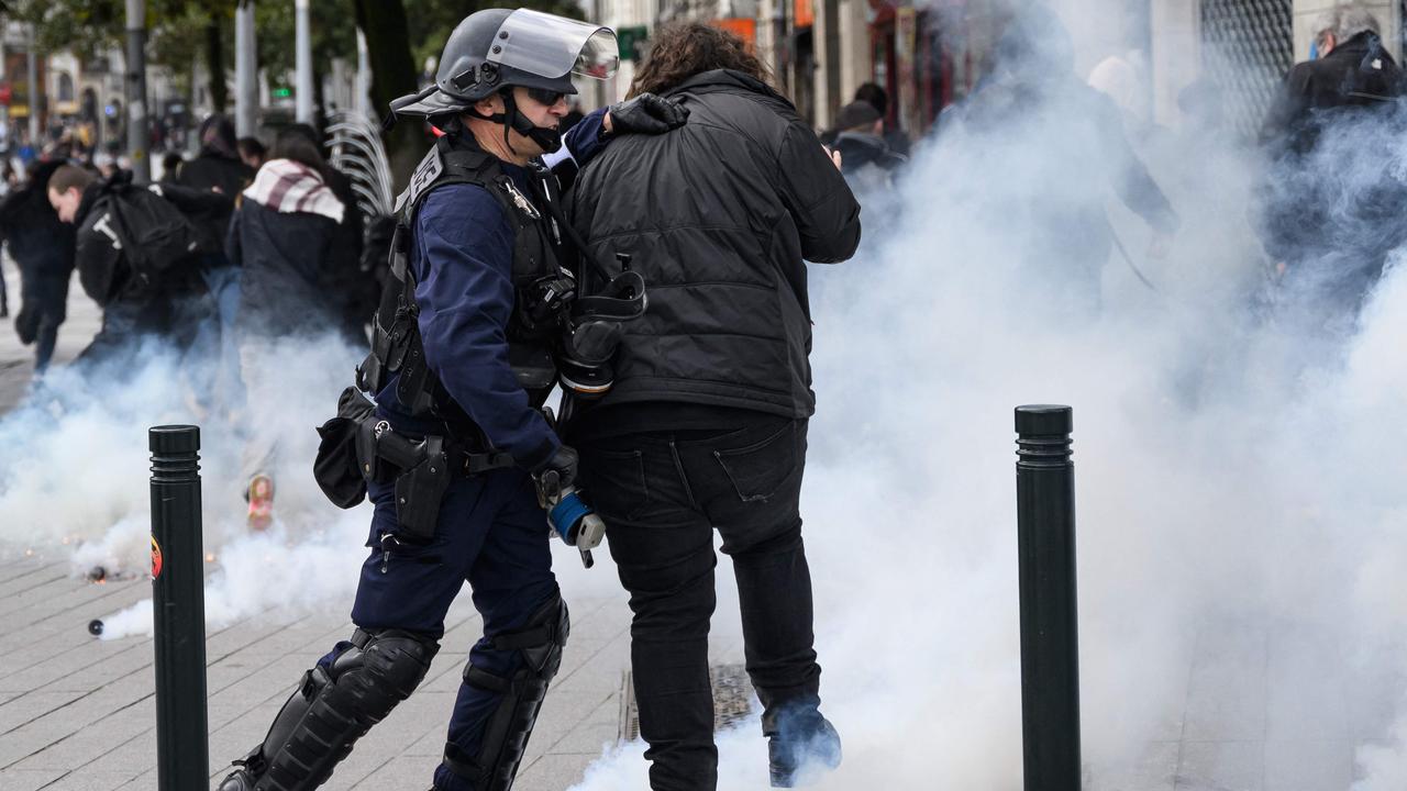 A police officer moves a protester during a demonstration in Nantes two days after the French government pushed a pensions reform through parliament without a vote. Picture: Loic Venance/AFP