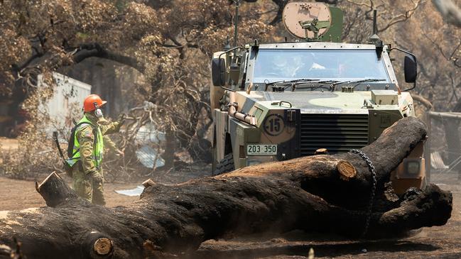 Corporal Dan Conelly a reservist from the 3rd Field Squadron, 10th/27th Battalion, Royal South Australia Regiment, works to remove a burnt tree from local farm’s access road on Kangaroo Island.