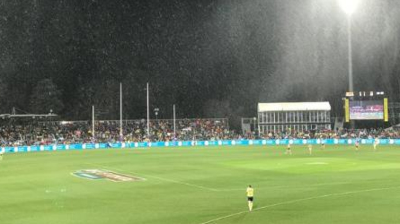 Snow falls over Manuka Oval during the clash between GWS and Hawthorn.