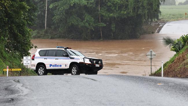 A tropical low between Innisfail and Townsville has dumped large amounts of rain in North Queensland, causing widespread flooding. Police inspect the Vic Sivyer Bridge, which was inundated by flood water flowing down the South Johnstone River. Picture: Brendan Radke