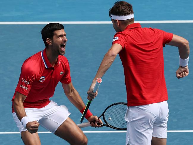 TOPSHOT - Serbia's Novak Djokovic (L) celebrates with teammate Filip Krajinovic (R) after winning against Canada's Milos Raonic and Denis Shapovalov during their group A men's doubles tennis match on day one of the 2021 ATP Cup in Melbourne on February 2, 2021. (Photo by DAVID GRAY / AFP) / -- IMAGE RESTRICTED TO EDITORIAL USE - STRICTLY NO COMMERCIAL USE --