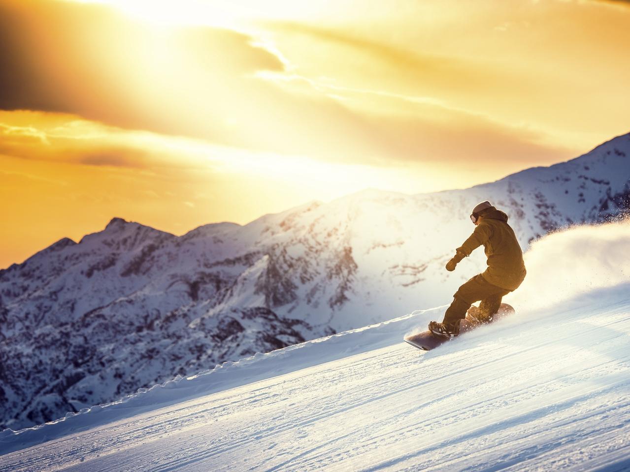Man snowboarding at dusk