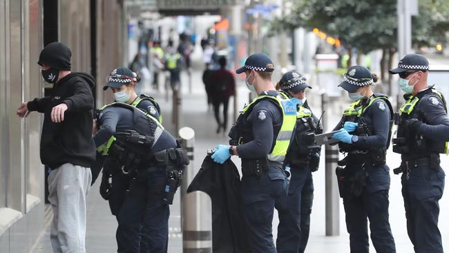 Police search a man on Bourke Street Mall. Picture: David Crosling