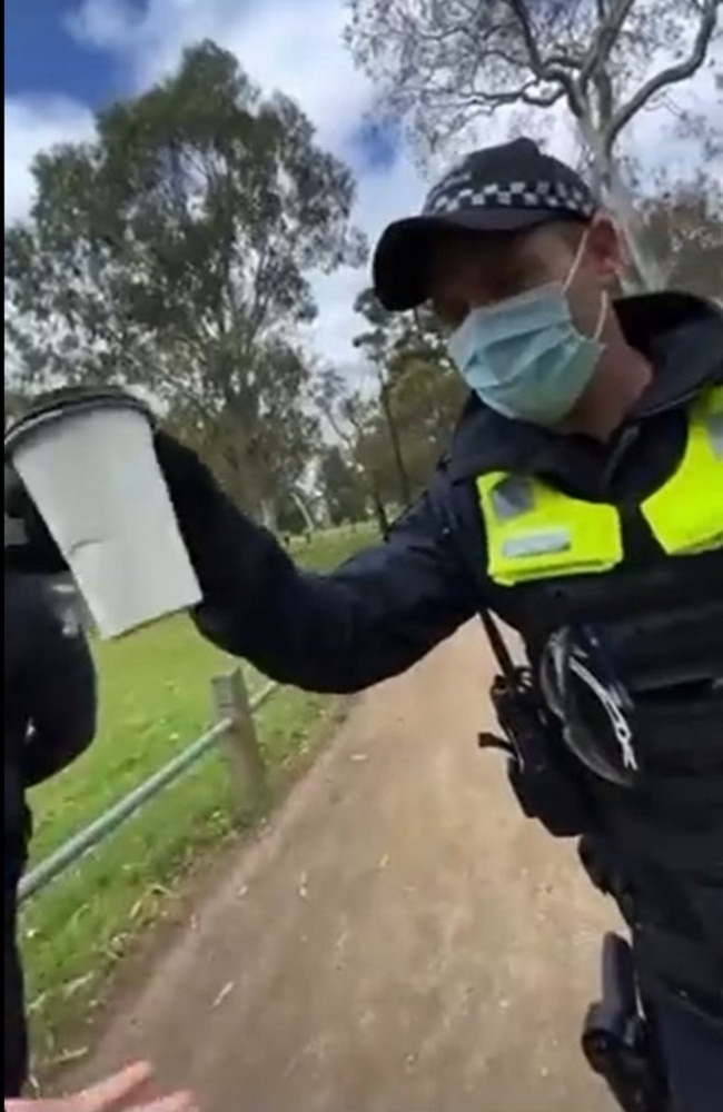 After shaking the cup, the policeman returned it and waved on the person. Picture: Twitter/@OzraeliAvi