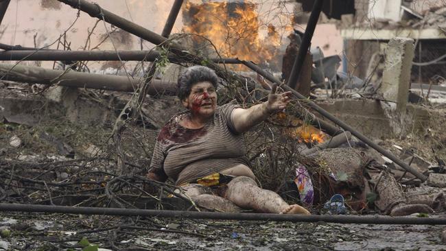 A wounded Georgian woman lies in front of an apartment building damaged by a Russian airstrike in northern Georgian in August 2008. Picture: AP