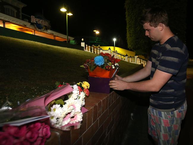 Hayden Woodgate leaves flowers at the scene of the accident at Dreamworld. Picture: Marc Robertson