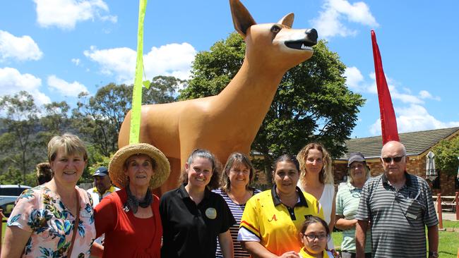 Steph Luck (third from left) and Fiona Barden (fourth from left) celebrates the official unveiling of the Golden Dog and its new and improved look on the Shop the Orara Valley weekend. Photo: Tim Jarrett