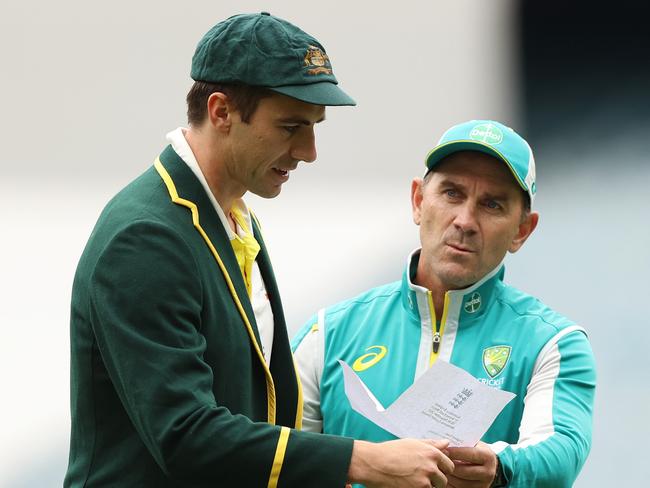 MELBOURNE, AUSTRALIA - DECEMBER 26: Pat Cummins of Australia and Australia head coach Justin Langer are seen with England's team list during day one of the Third Test match in the Ashes series between Australia and England at Melbourne Cricket Ground on December 26, 2021 in Melbourne, Australia. (Photo by Robert Cianflone/Getty Images)