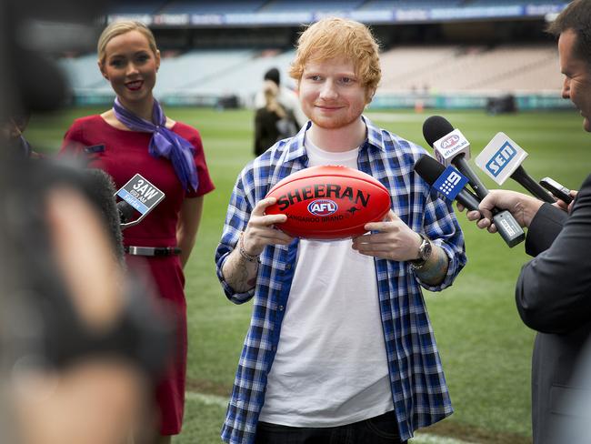 Ed Sheeran with his special ‘Sheeran’ Sherrin footy. Picture: Nathan Dyer