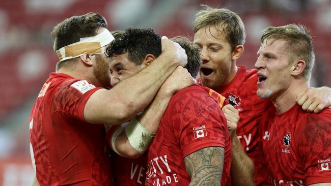 Mike Fuailefau of Canada celebrates with teammates after scoring a try.