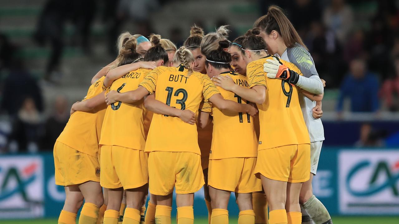 The Matildas players gather in a huddle.