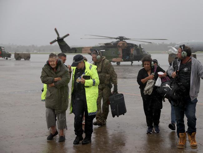 An army aircrewman and Queensland Police Service officers assist residents in south-east Queensland rescued by an army MRH-90 Taipan helicopter aircrew from the School of Army Aviation. Picture: ADF/ AFP